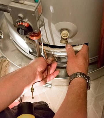 Hands replacing a component on a water heater
